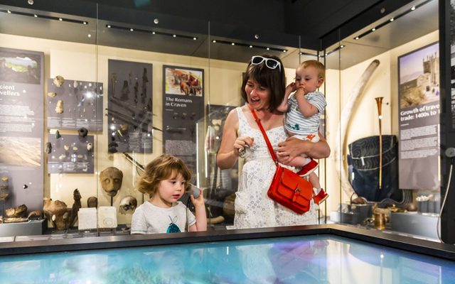 Mother with two children using an interactive display in the museum