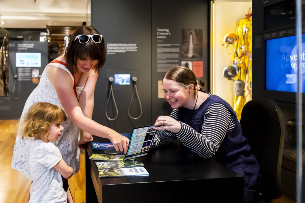 Skipton Town Hall_245 Museum staff talking to visitors and showing them a leaflet.