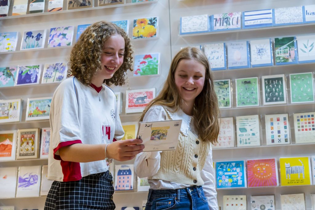 Skipton Town Hall_77 Two teenage girls looking at a greetings card and smiling.