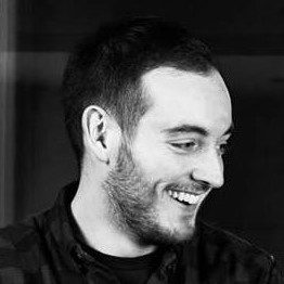 Ted 2 Man with short dark hair and a short beard. he is looking to the side and smiling.