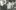 2018.180.4 Old black and white photo of a mill worker with a rack of large cotton reels.