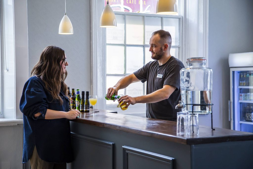 Skipton Town Hall_266 a man serves a drink to a woman at a bar