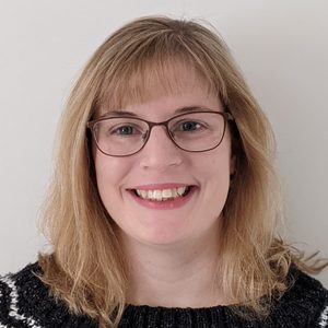 Chloe A woman with shoulder length blonde hair and glasses. She is smiling.