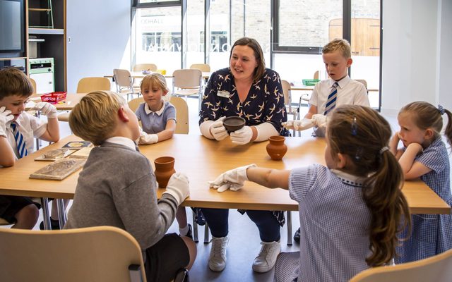 A teacher and children sitting around a table